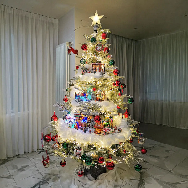 Albero di Natale con villaggio illuminato e base innevata in un salotto elegante