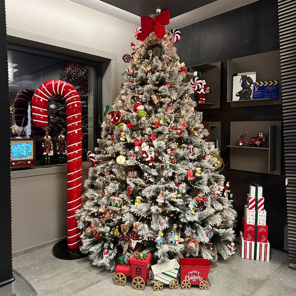 Albero di Natale innevato con bastoncino di zucchero gigante e pacchi regalo
