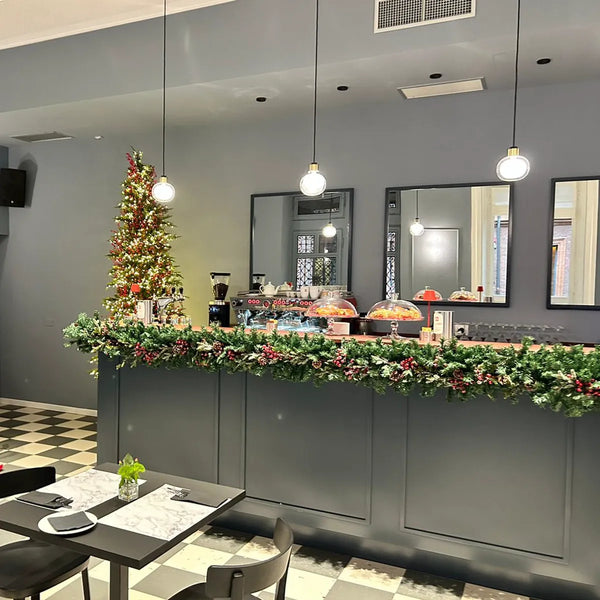 Bancone di un bar decorato con ghirlanda e albero di Natale