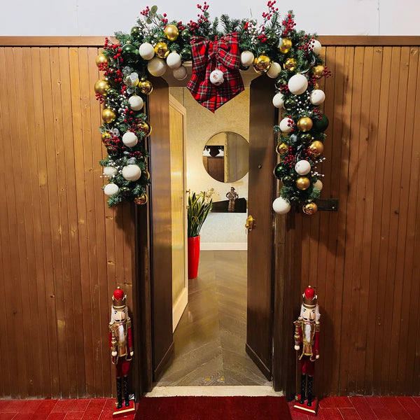 Porta decorata con ghirlanda, fiocco scozzese e schiaccianoci