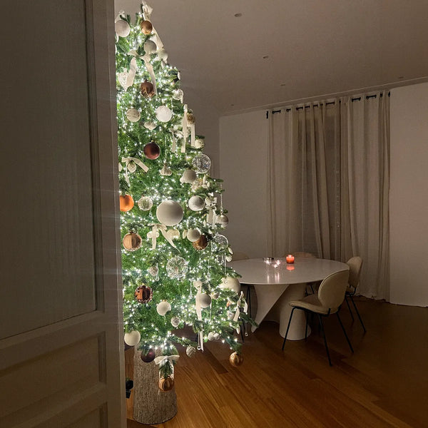 Albero di Natale illuminato accanto a un tavolo da pranzo