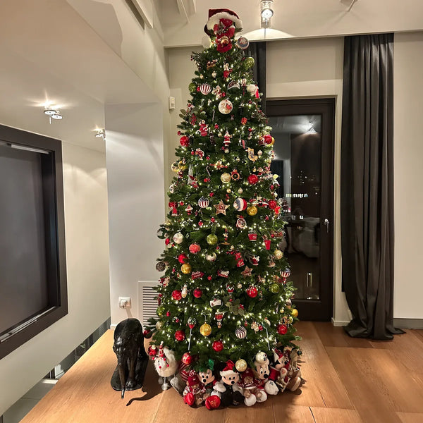 Albero di Natale alto con palline rosse e bianche in un ingresso