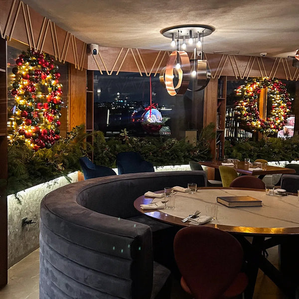 Sala di un ristorante con ghirlande e corone natalizie illuminate